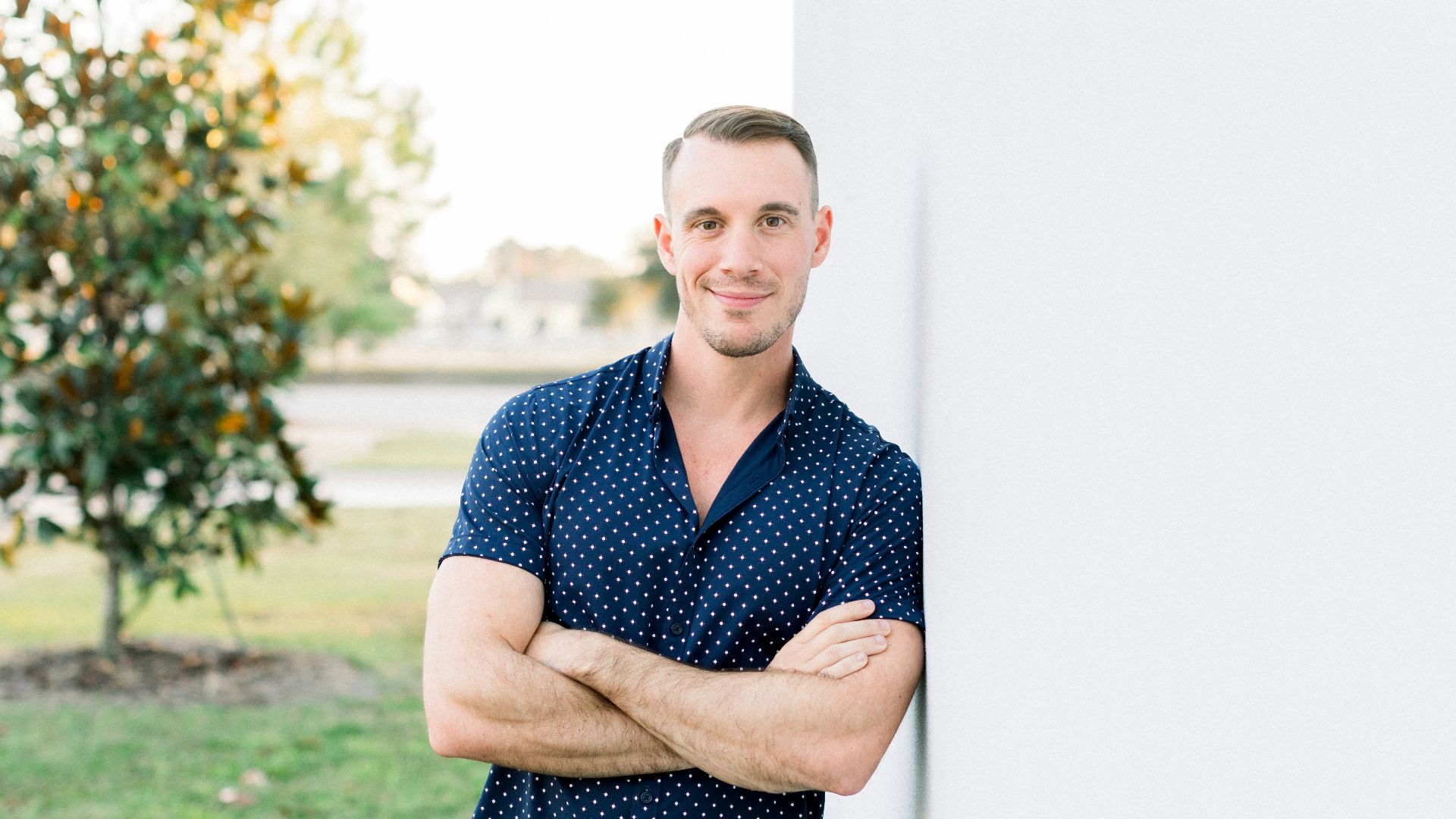 a man leaning against a wall with his arms crossed
