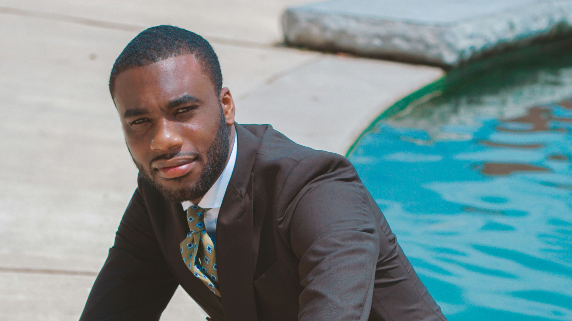 man in black 2-piece suit near swimming pool