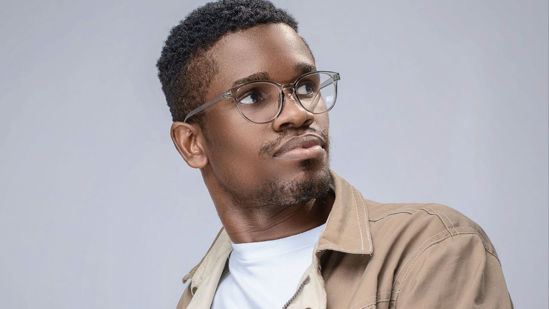 man in brown button up jacket wearing black framed eyeglasses