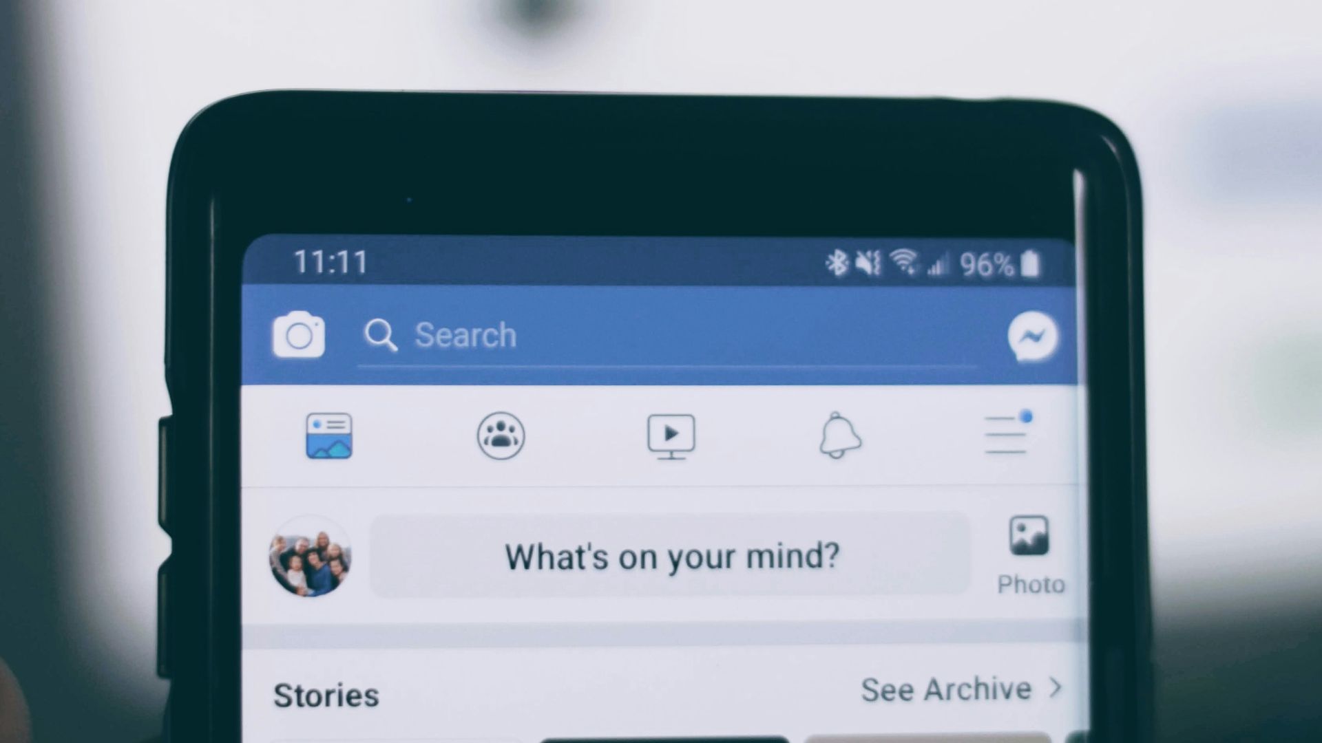 person holding smartphone using facebook account