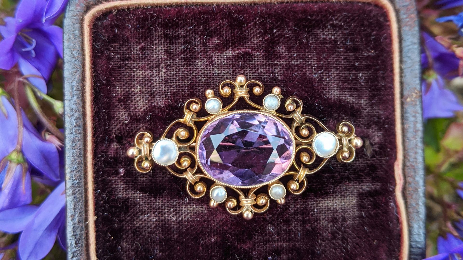 gold and silver round analog watch on black and purple case