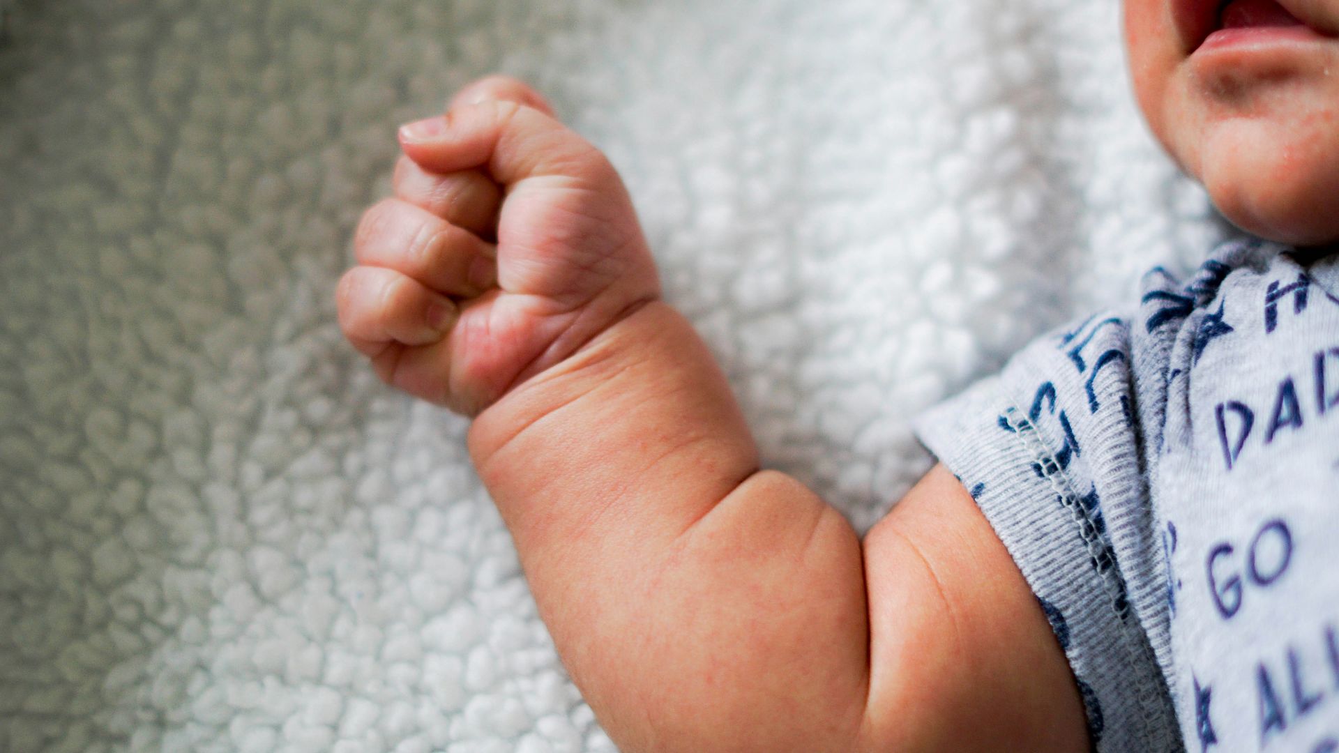 babys feet on white textile