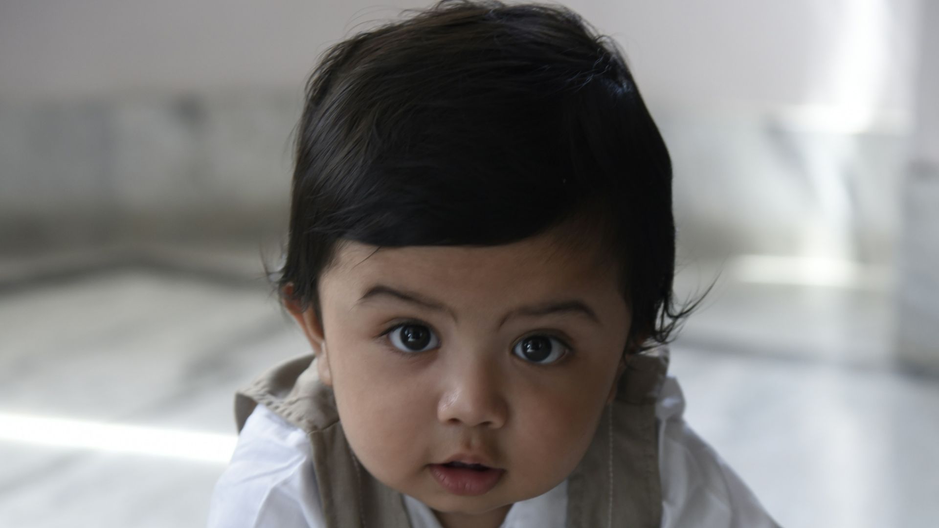 a baby wearing a tie crawling on the floor
