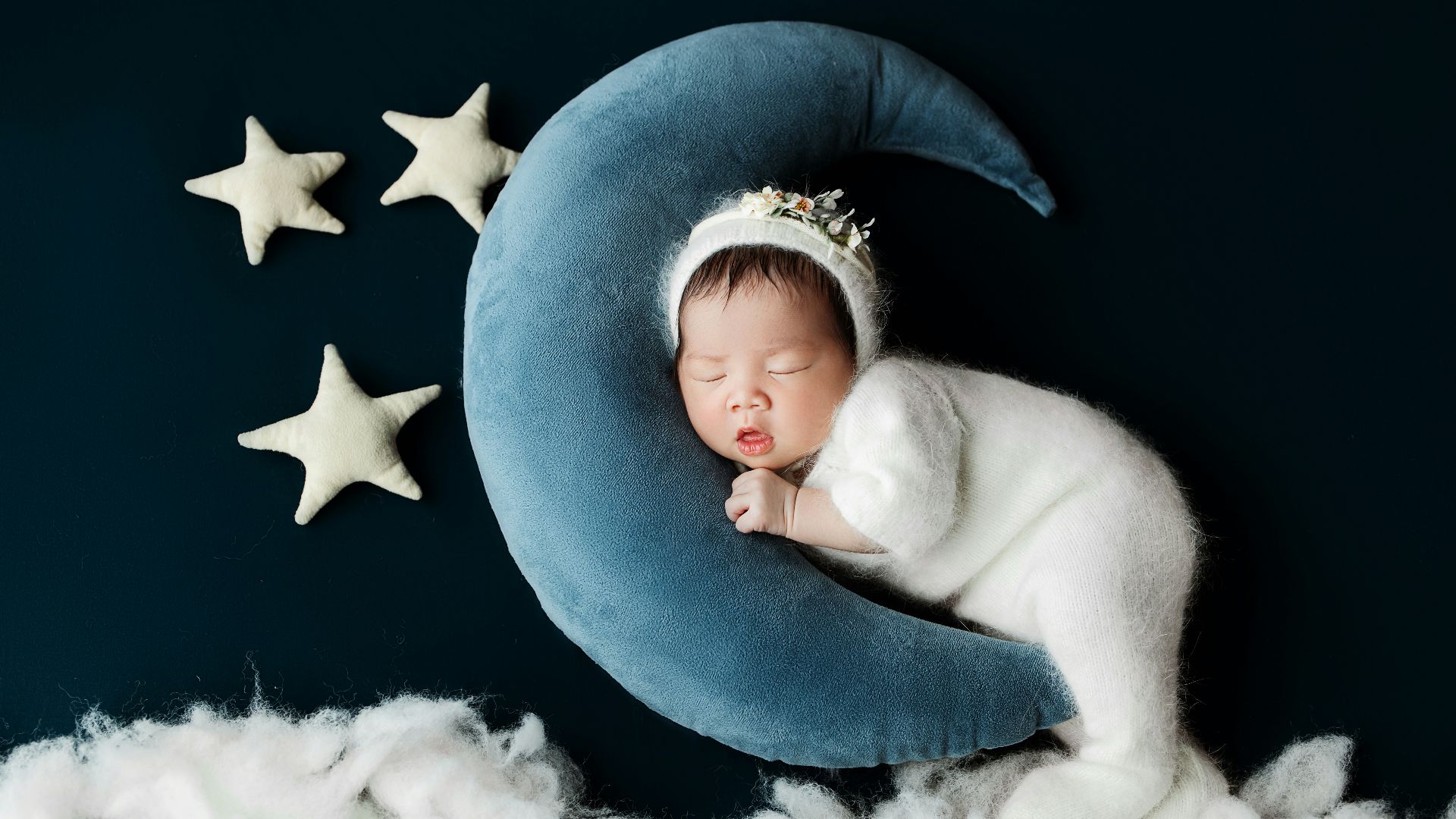 A baby sleeping on top of a blue moon