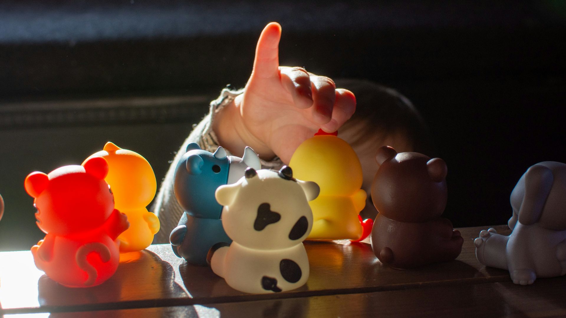 a baby reaching for a toy on a table