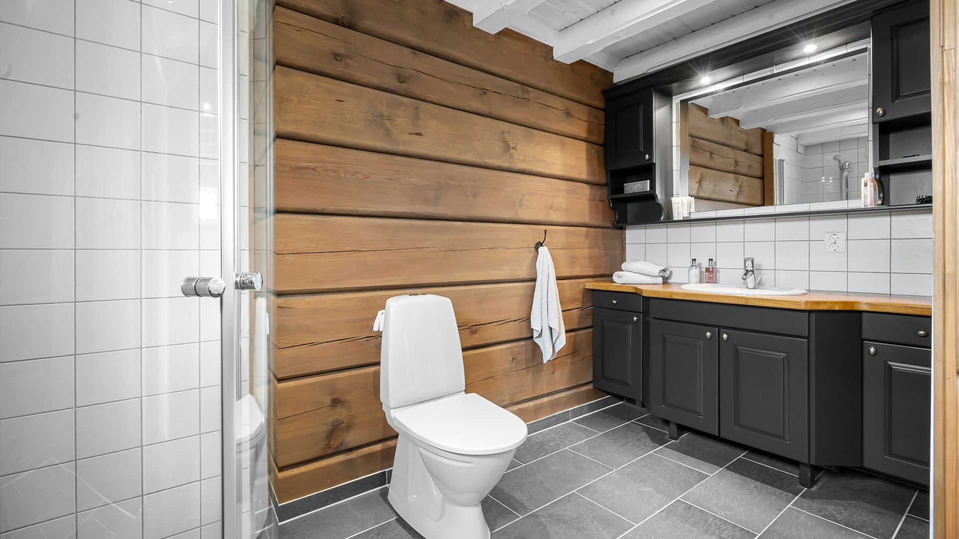 A white toilet sitting next to a wooden wall
