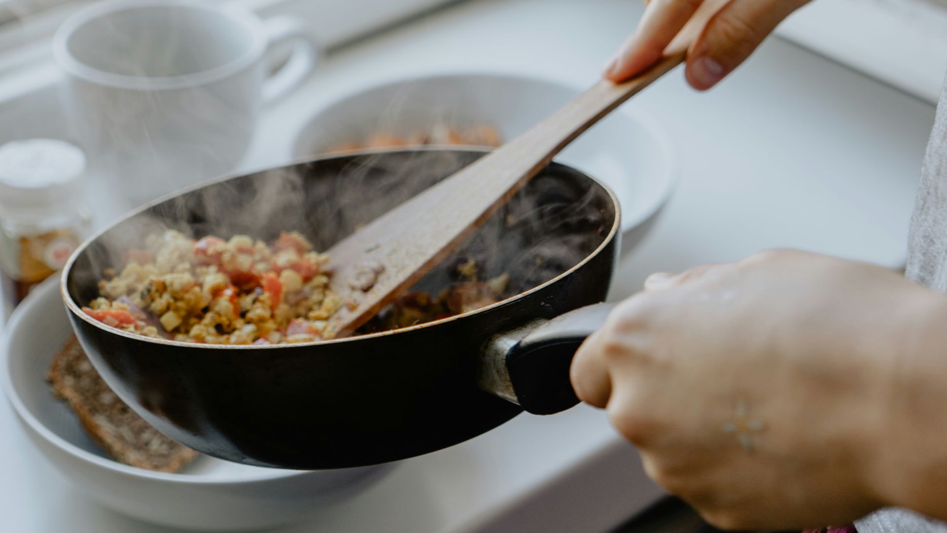 person holding black frying pan