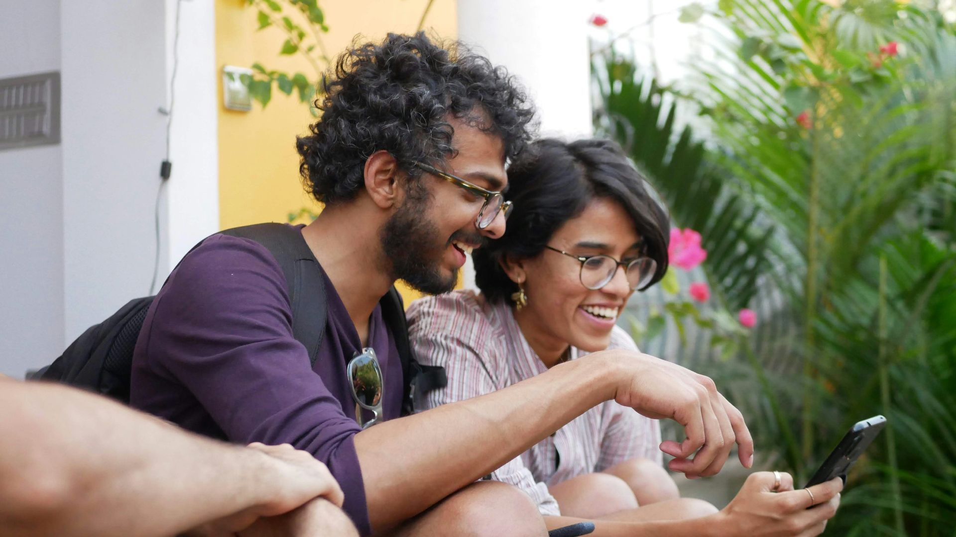 man in black polo shirt sitting beside woman in purple shirt