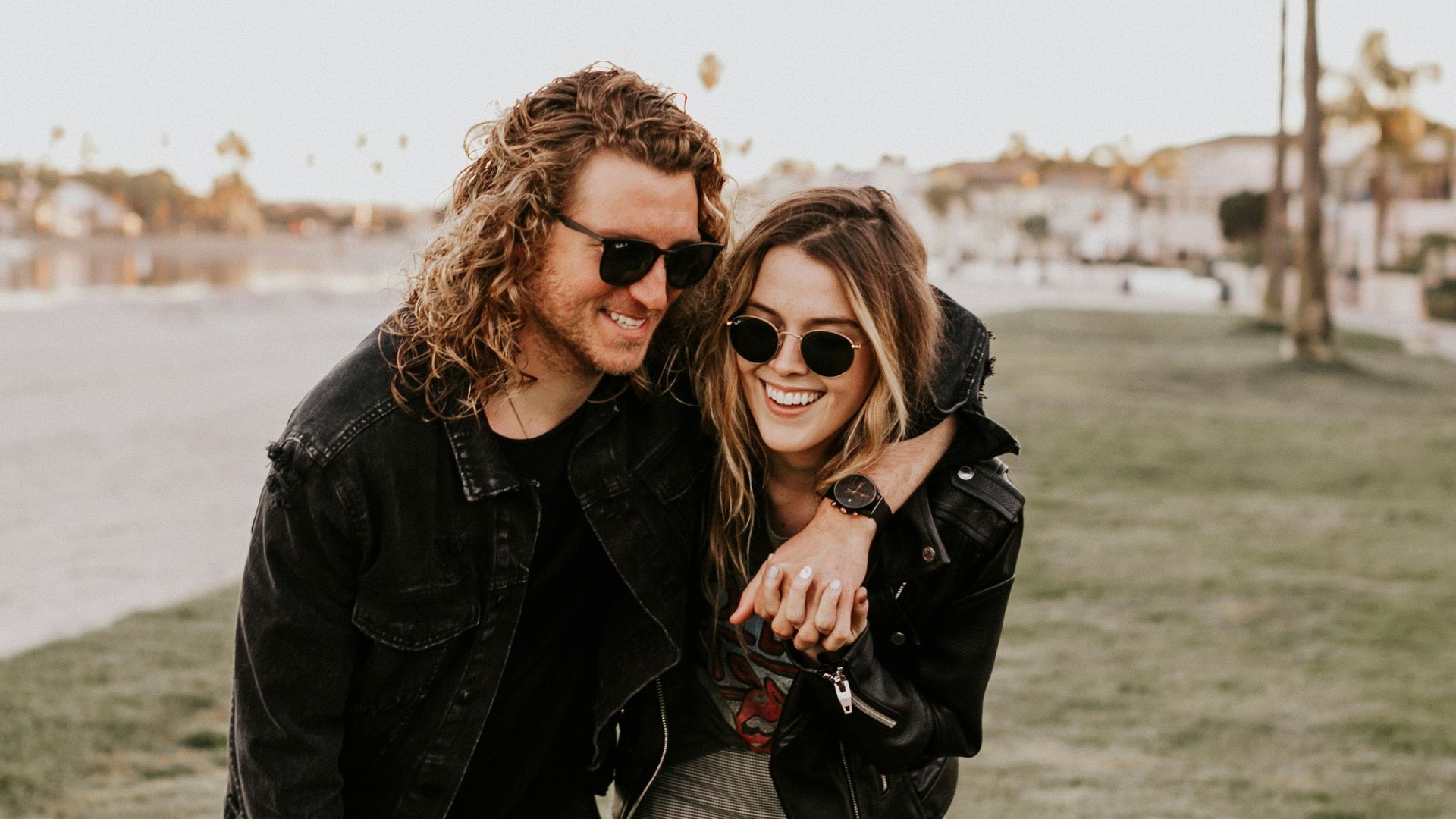 woman in black leather jacket and gray pants standing on green grass field during daytime