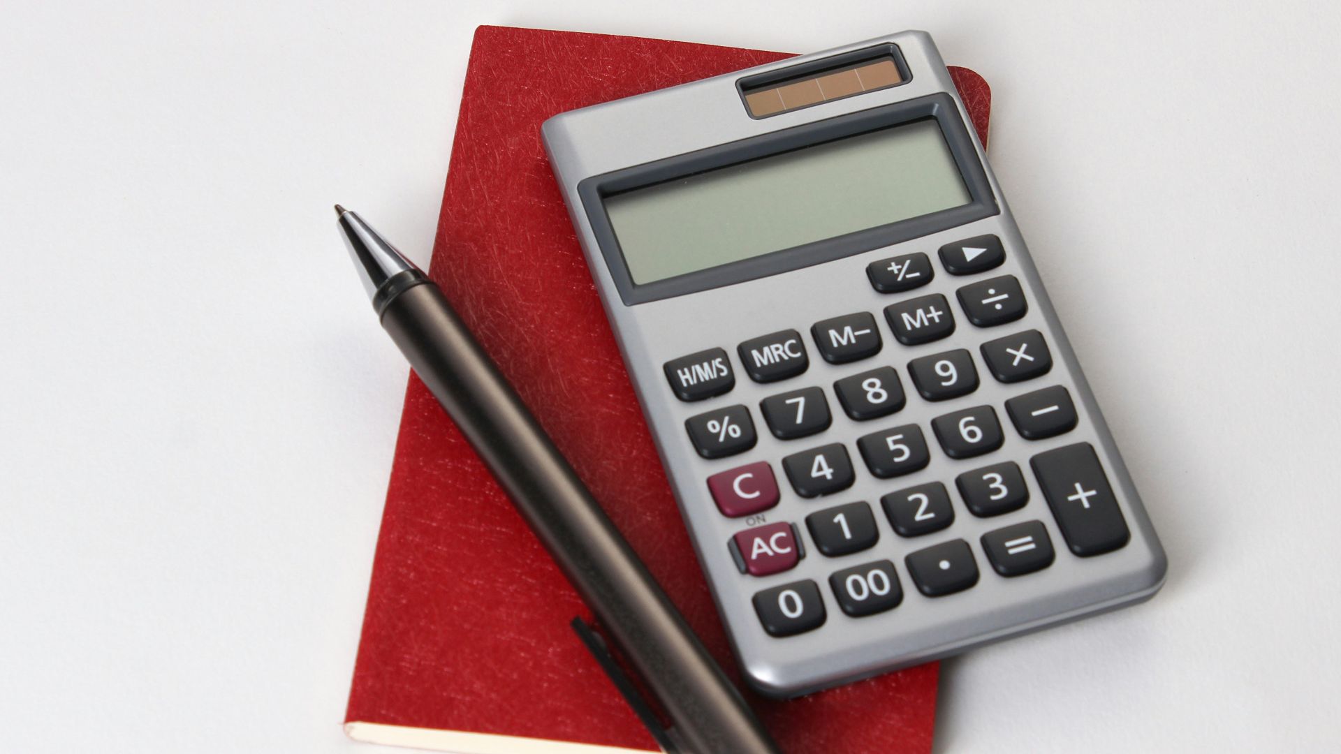 black and silver calculator beside black pen
