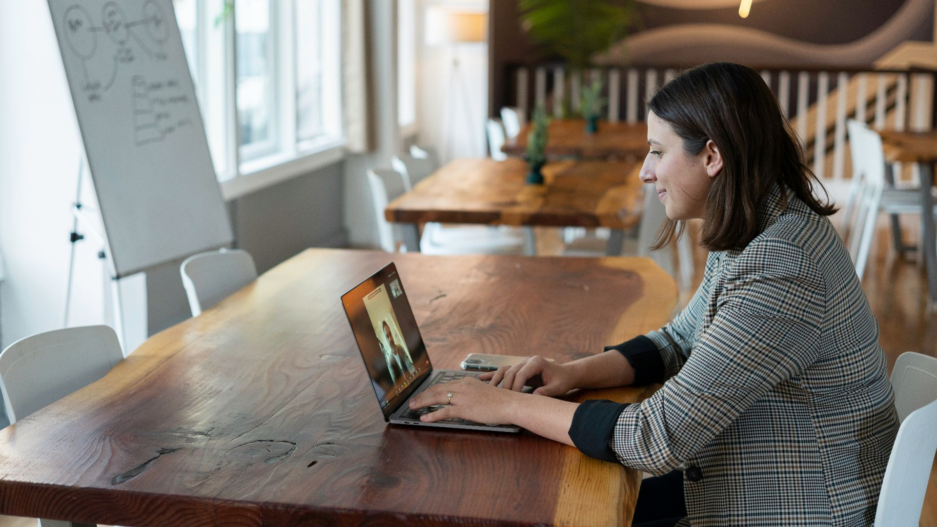 woman in gray and white striped long sleeve shirt using silver macbook