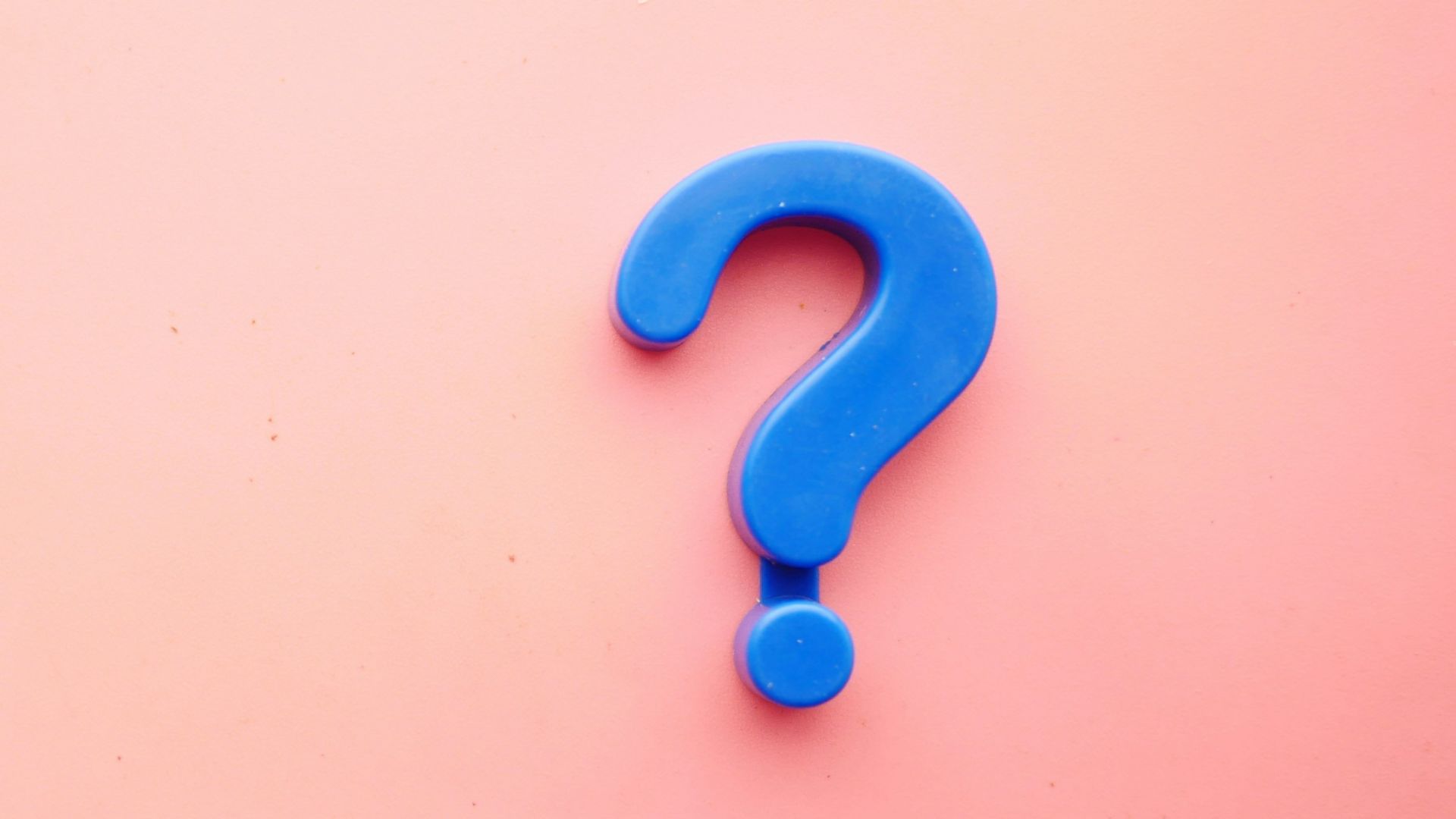 a blue question mark on a pink background