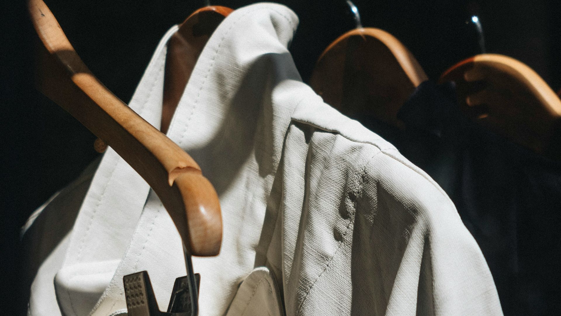 white dress shirt hanged on brown wooden clothes hanger