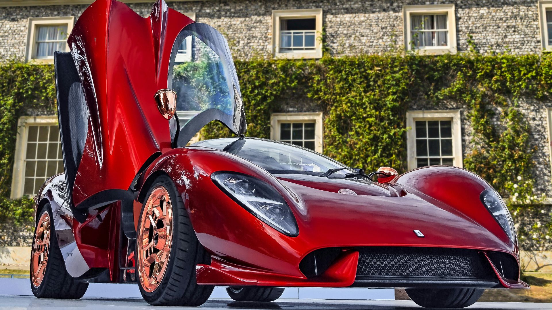 red sports coupe parked by stone-walled building at daytime