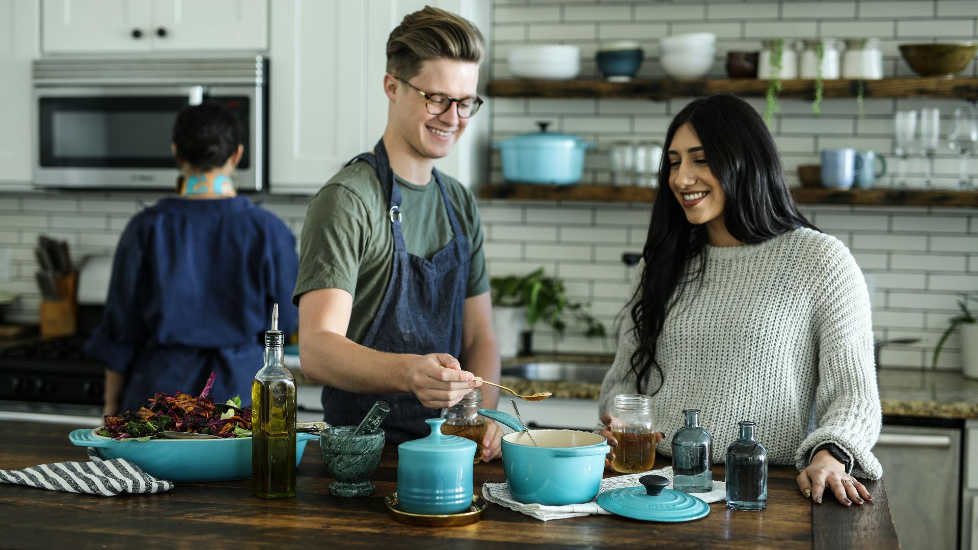 smiling man standing and mixing near woman in kitchen area of the house