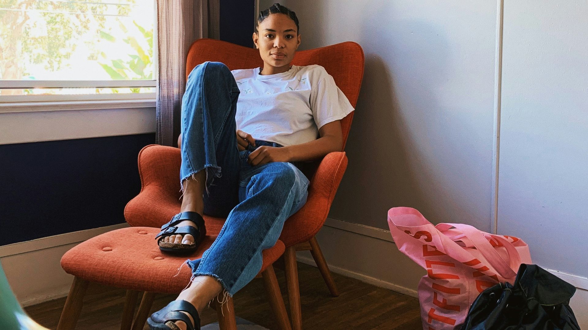 woman sitting on sofa chair beside window
