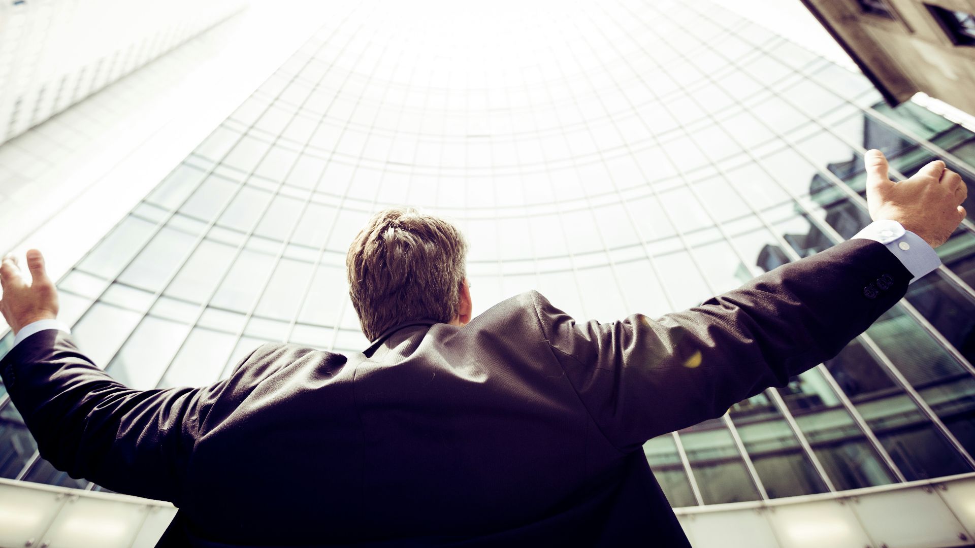 low-angle photography of man in the middle of buidligns