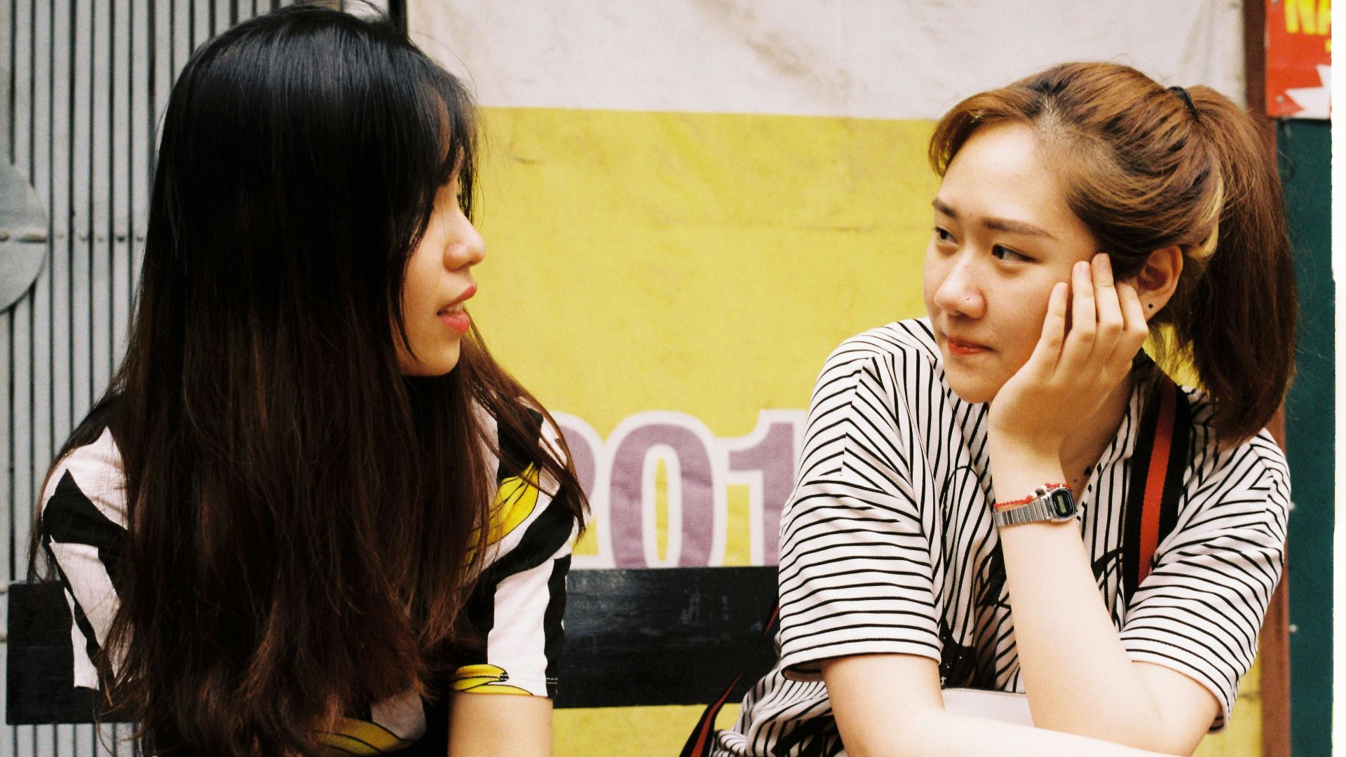 woman in white-and-black striped tops looking each other