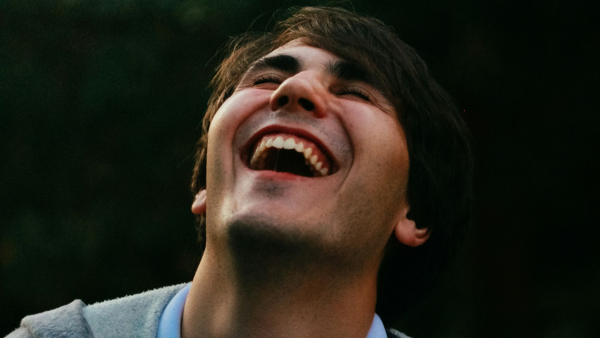 man in gray sweater smiling