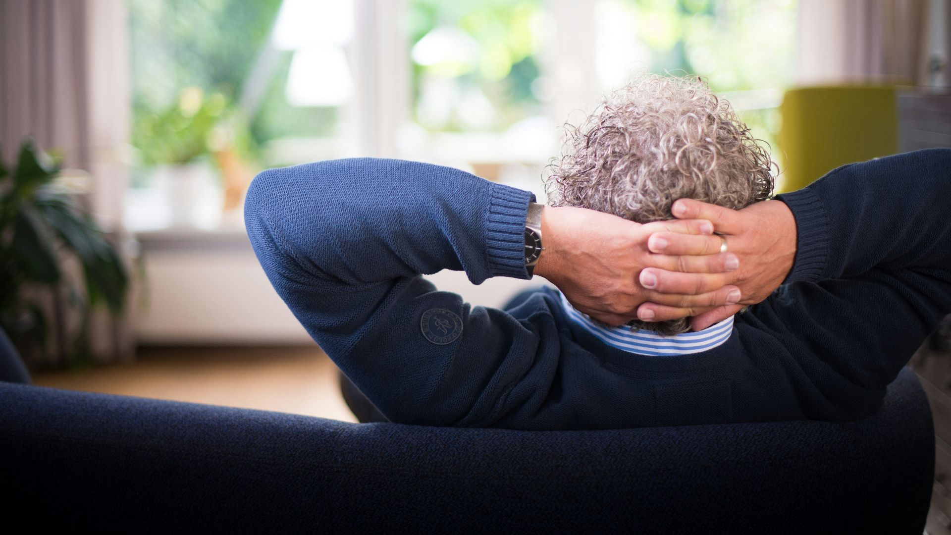 man lying on black couch