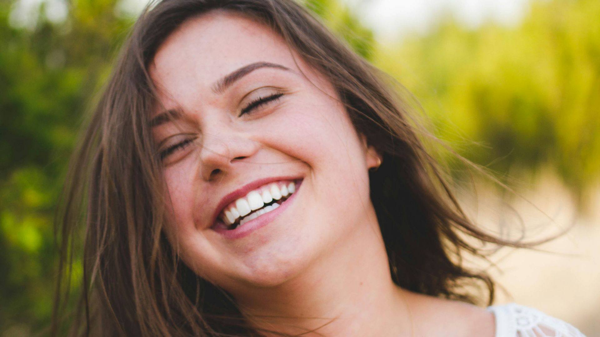 woman smiling wearing white top