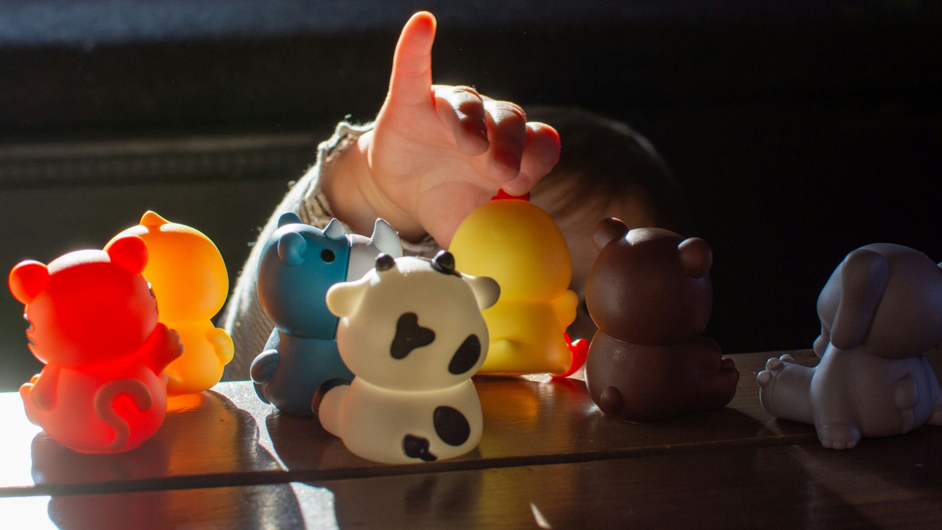 a baby reaching for a toy on a table