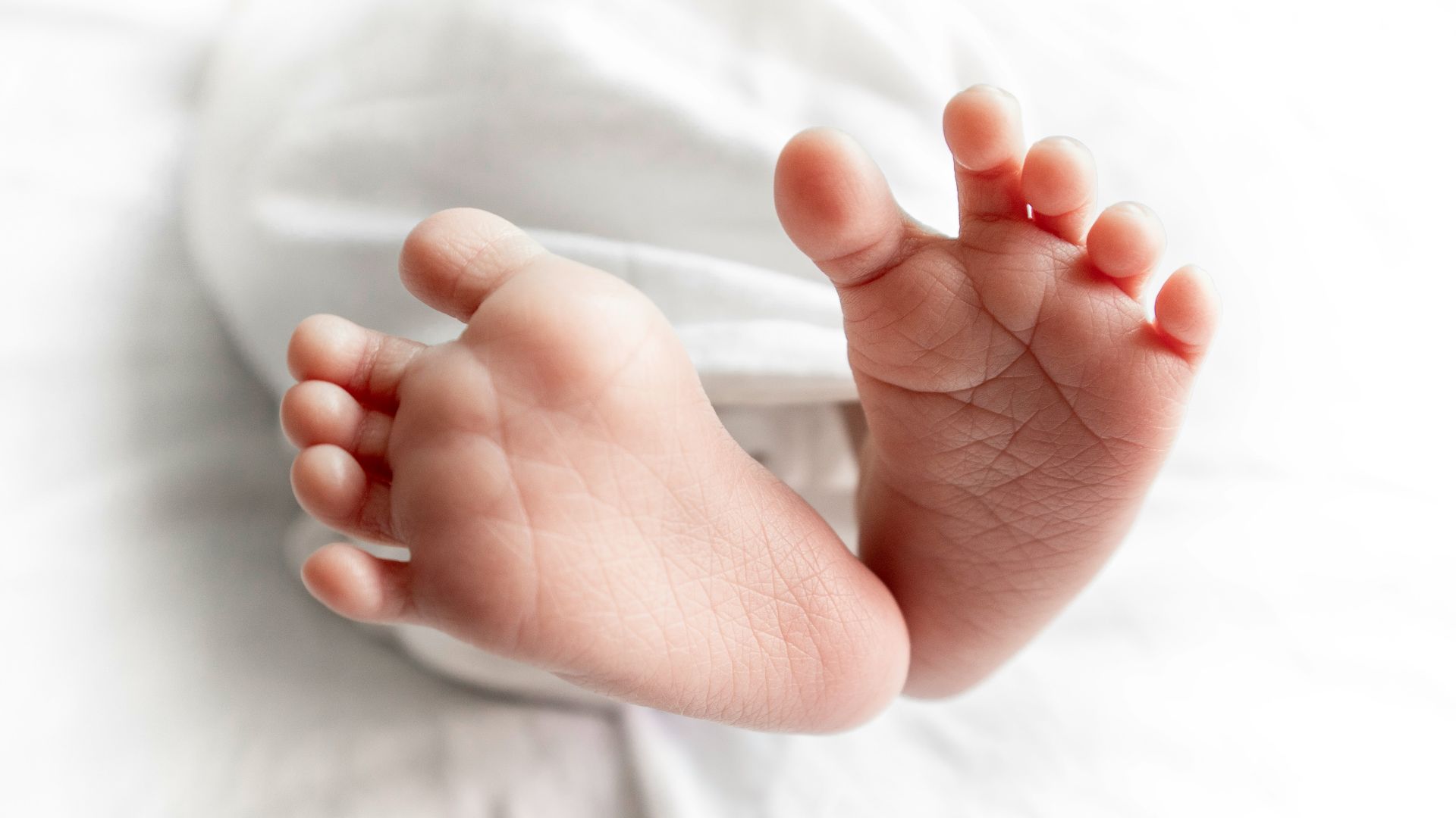 a close up of a baby's bare feet on a bed