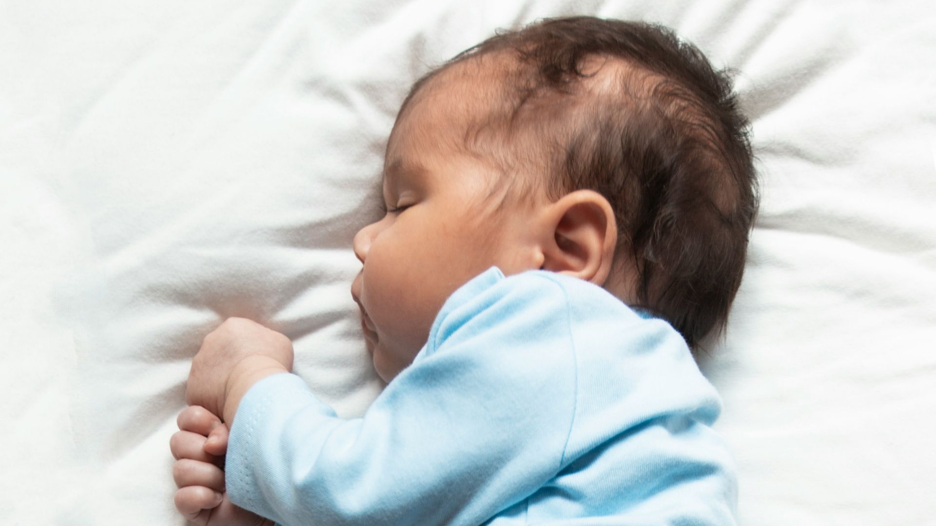 woman in teal pajama lying on bed