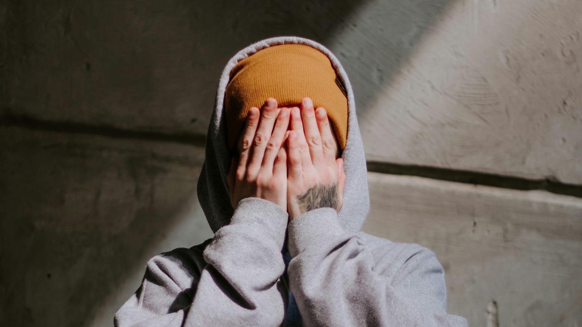 person in gray hoodie wearing brown leather shoes