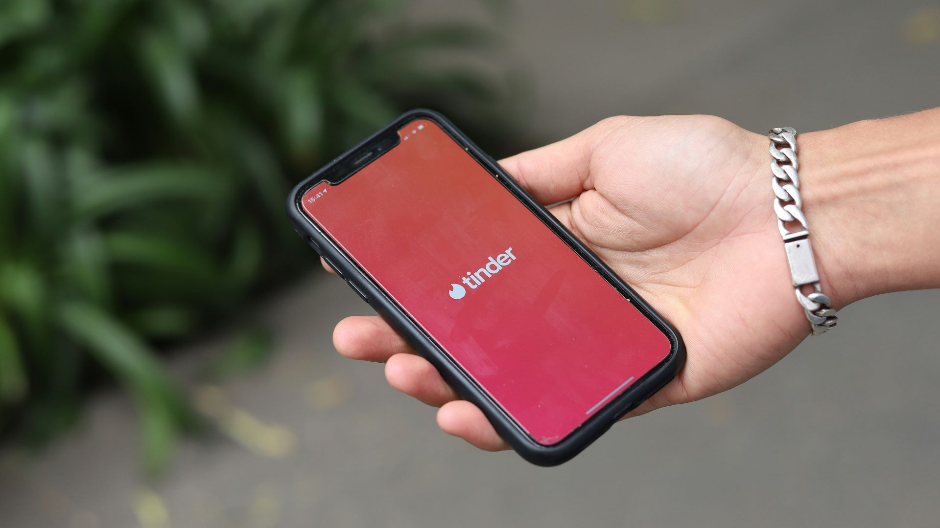 a person holding a red cell phone in their hand