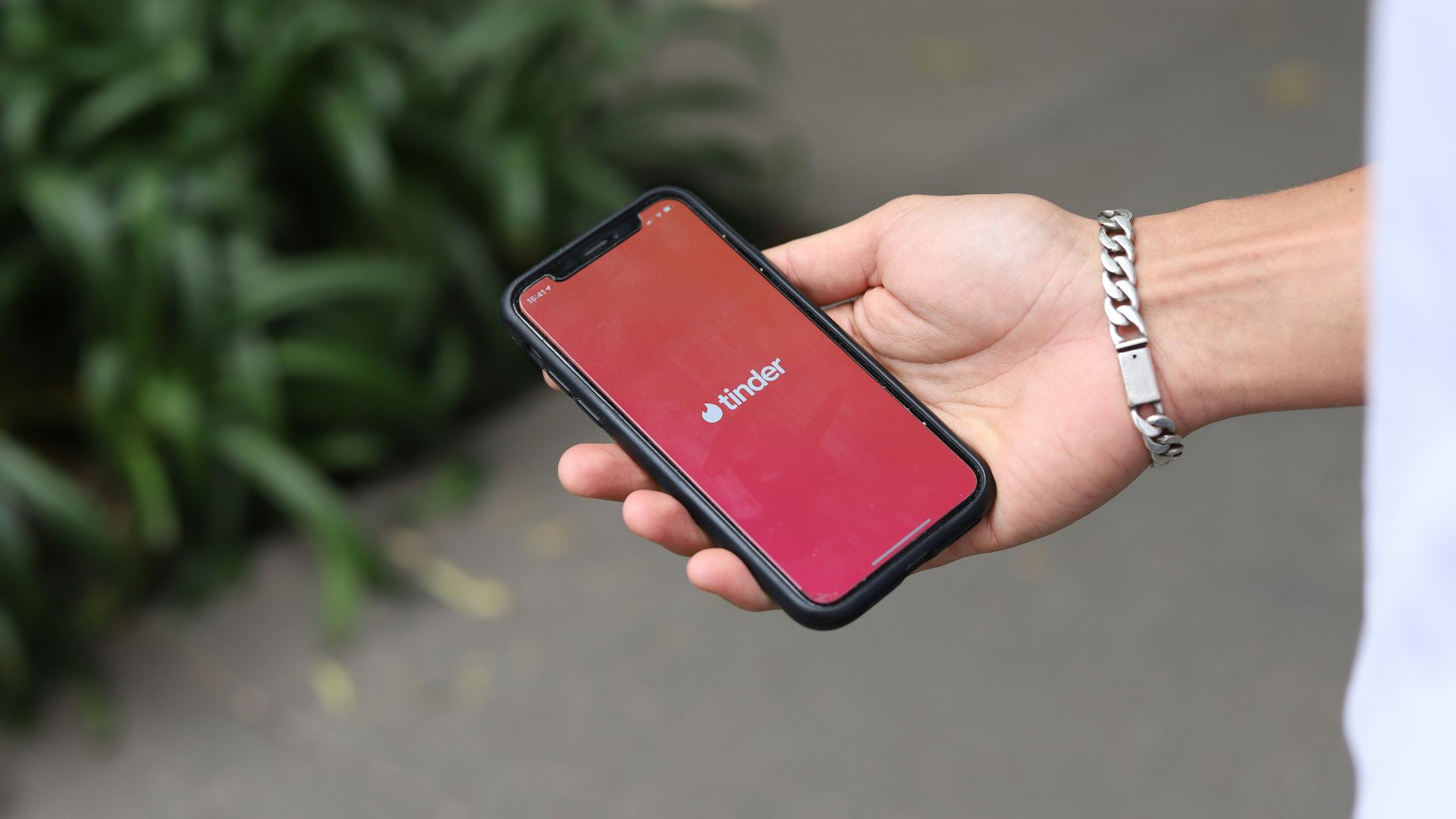 a person holding a red cell phone in their hand
