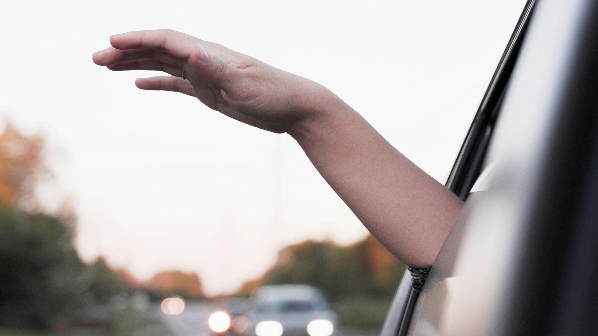 a hand reaching out of a car window