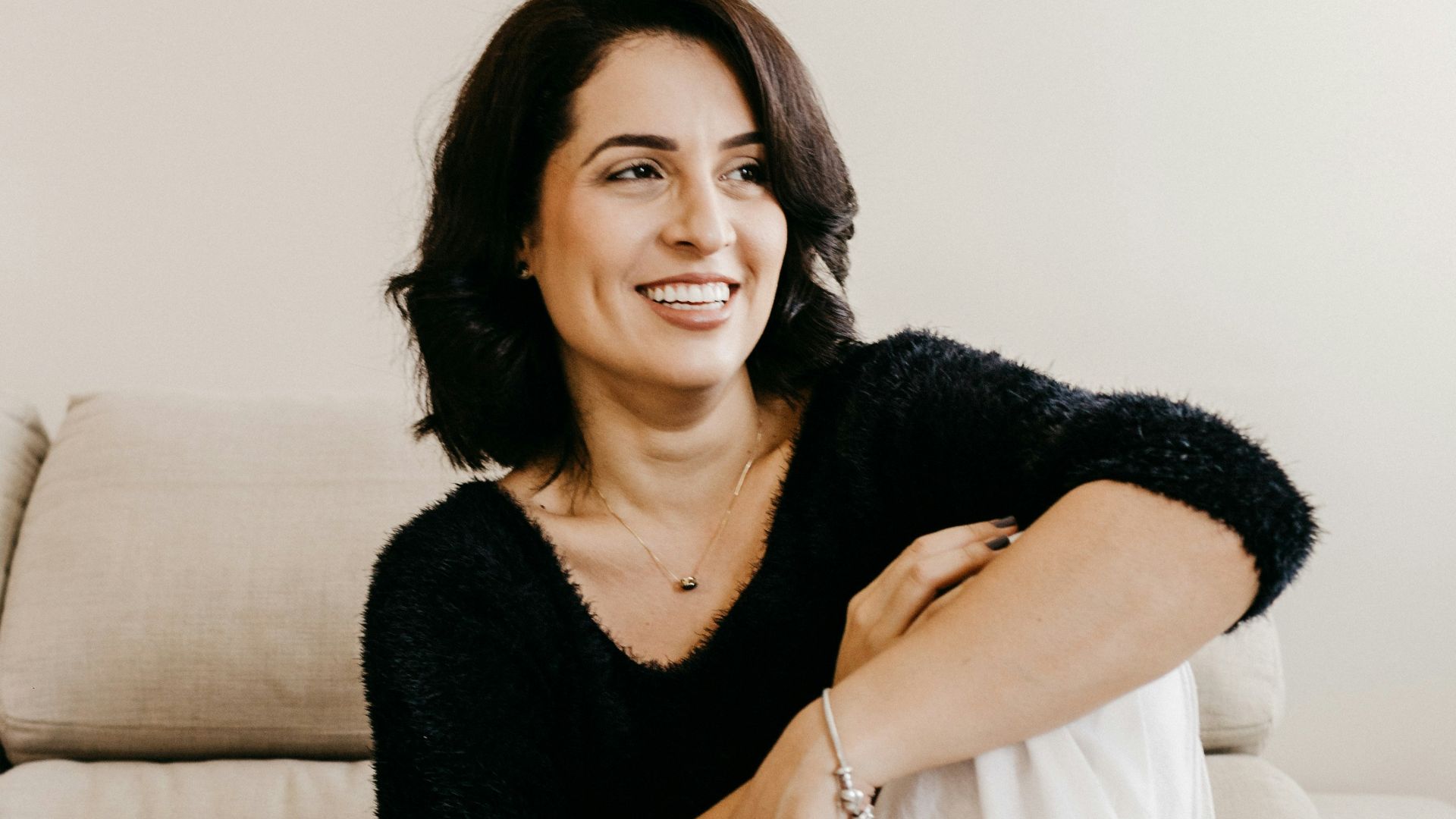 woman in black long sleeve shirt sitting on white couch