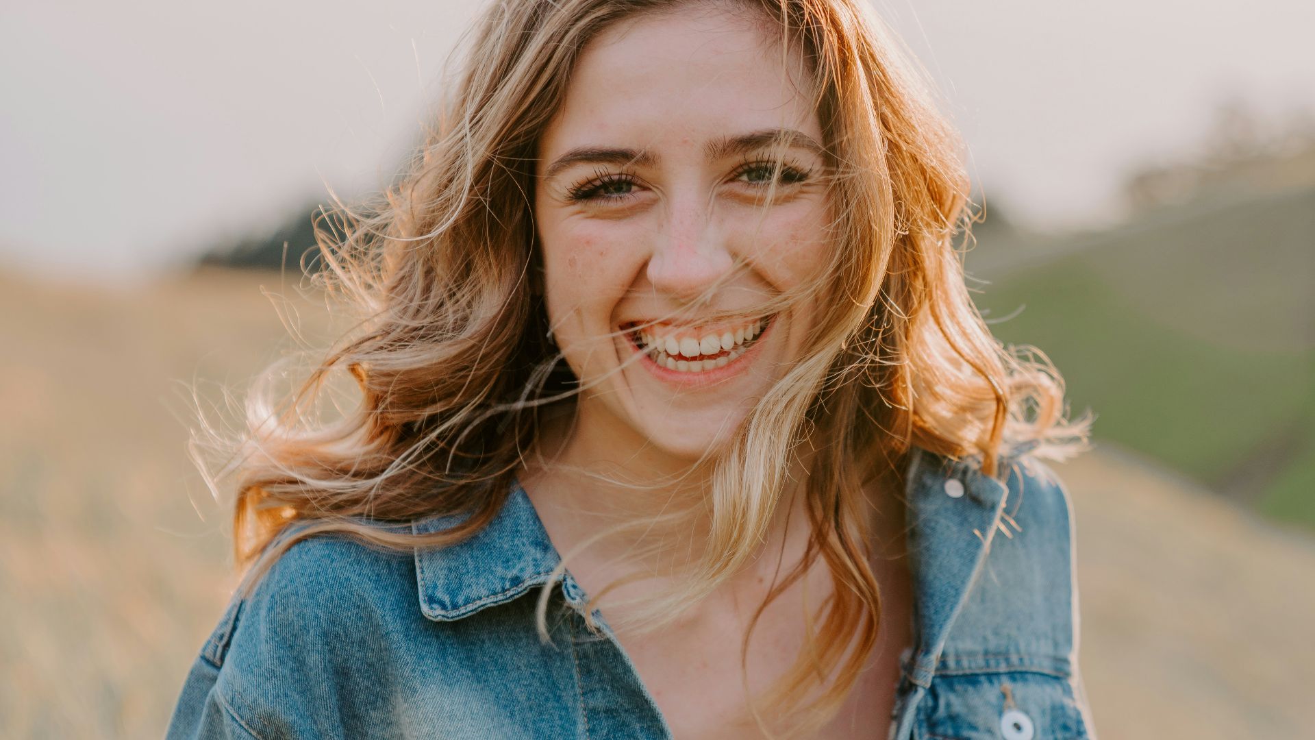 smiling woman sitting on grass during daytime
