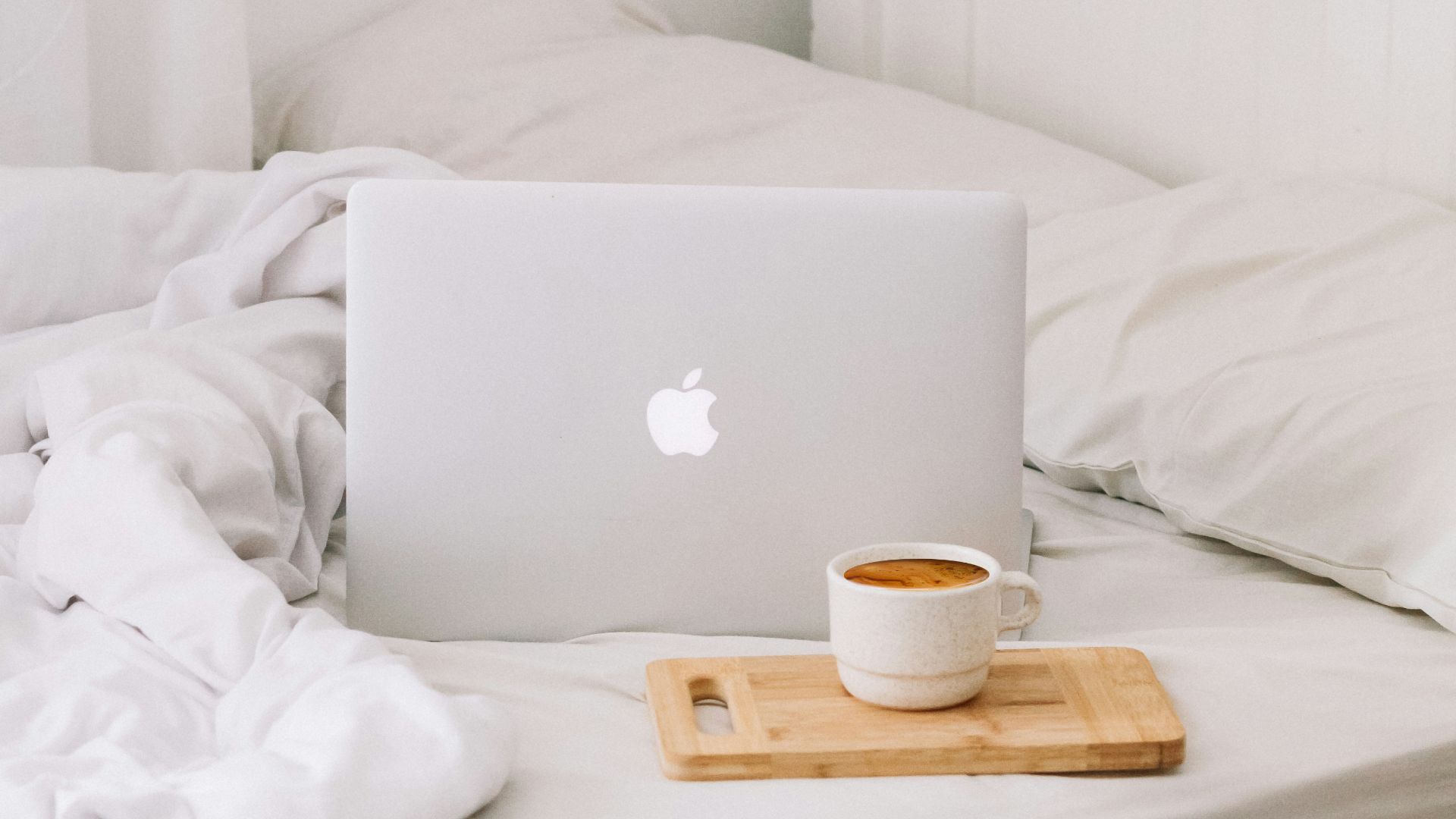 MacBook beside teacup with latte
