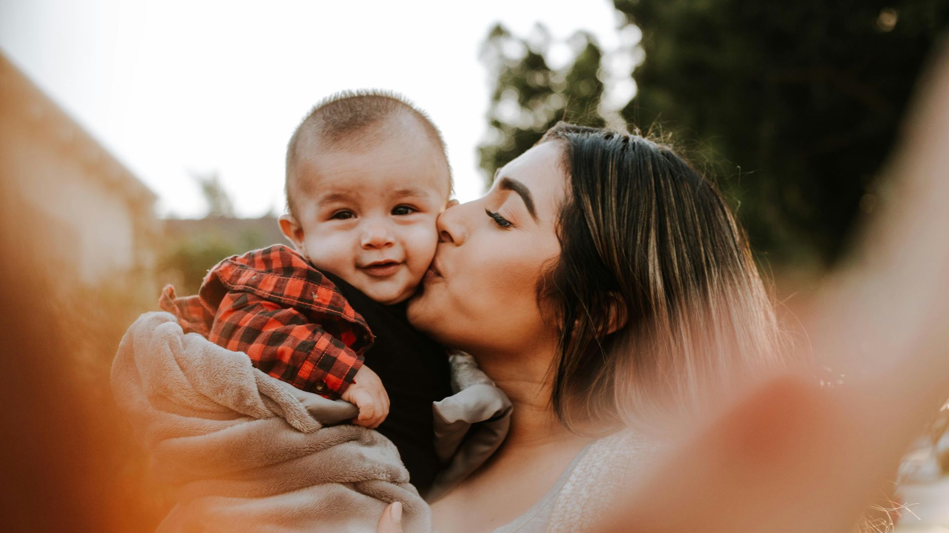 woman kiss a baby while taking picture