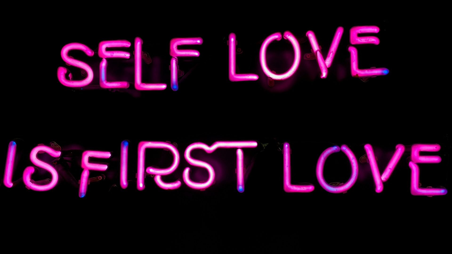 a neon sign that says self love is first love