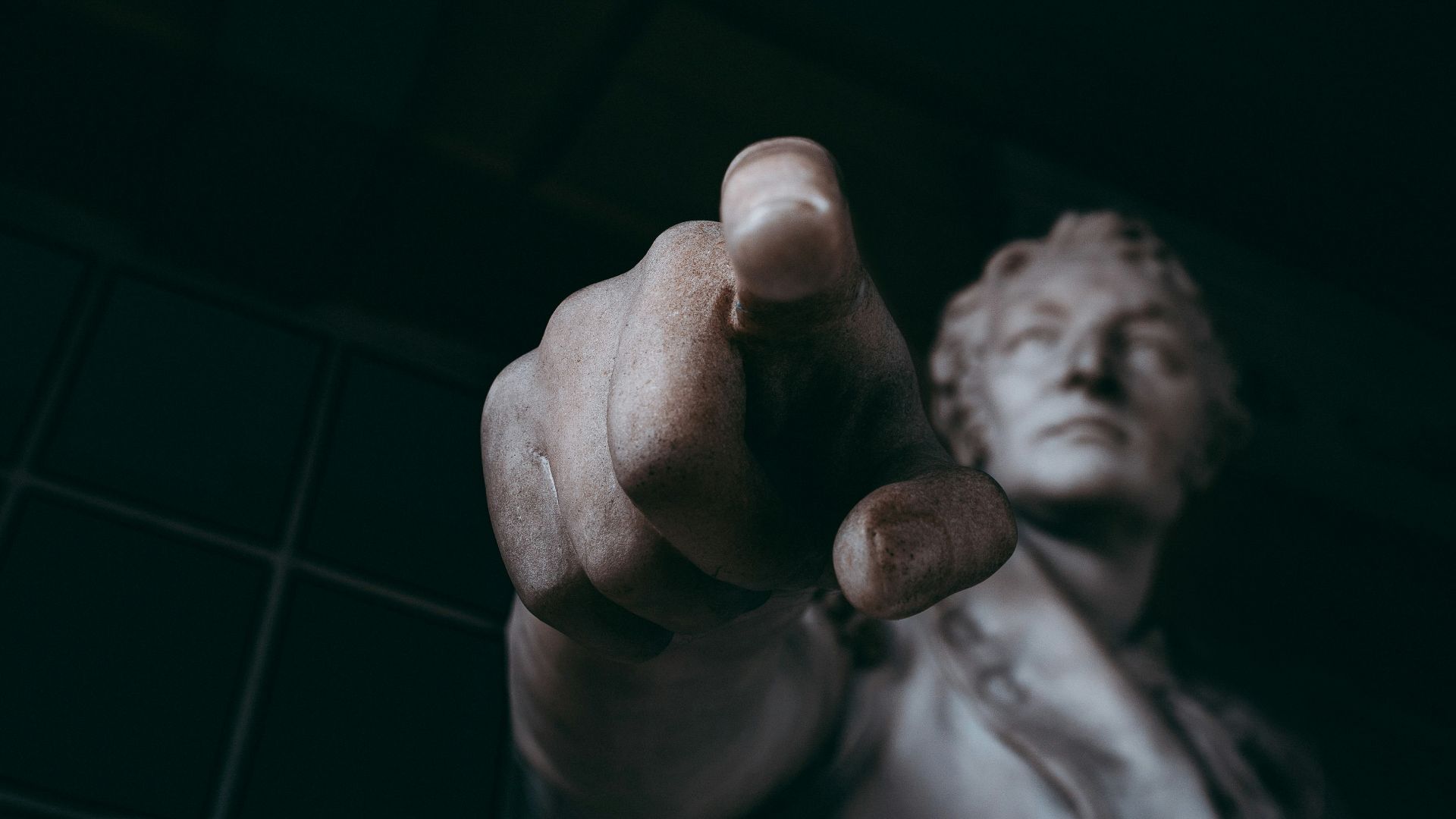 a statue of a man pointing at the camera