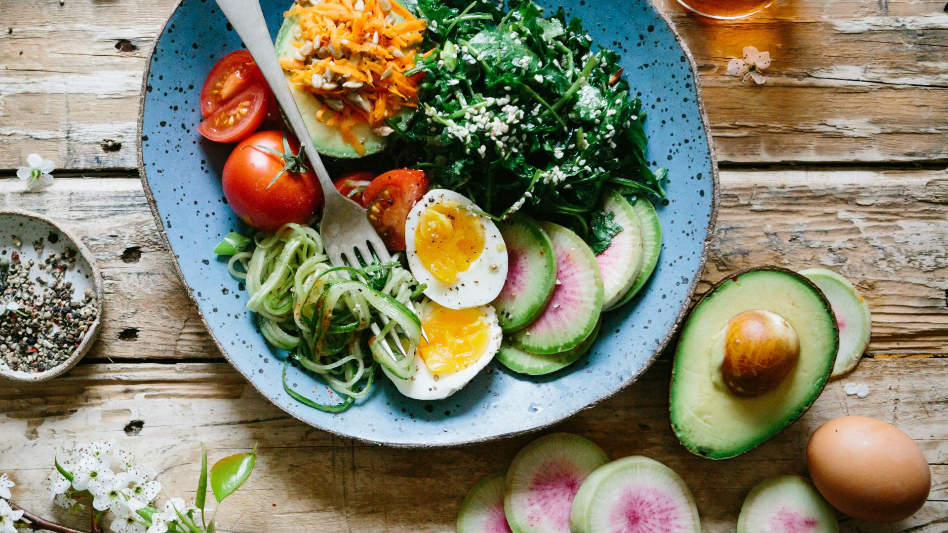 poached egg with vegetables and tomatoes on blue plate