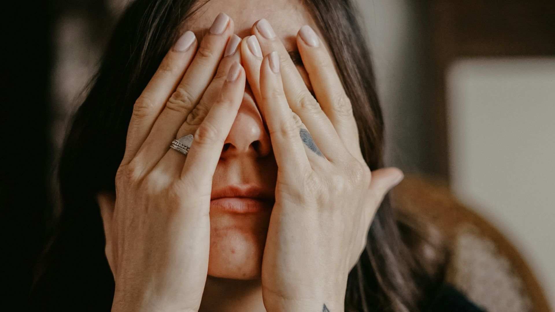 woman in black long sleeve shirt covering her face