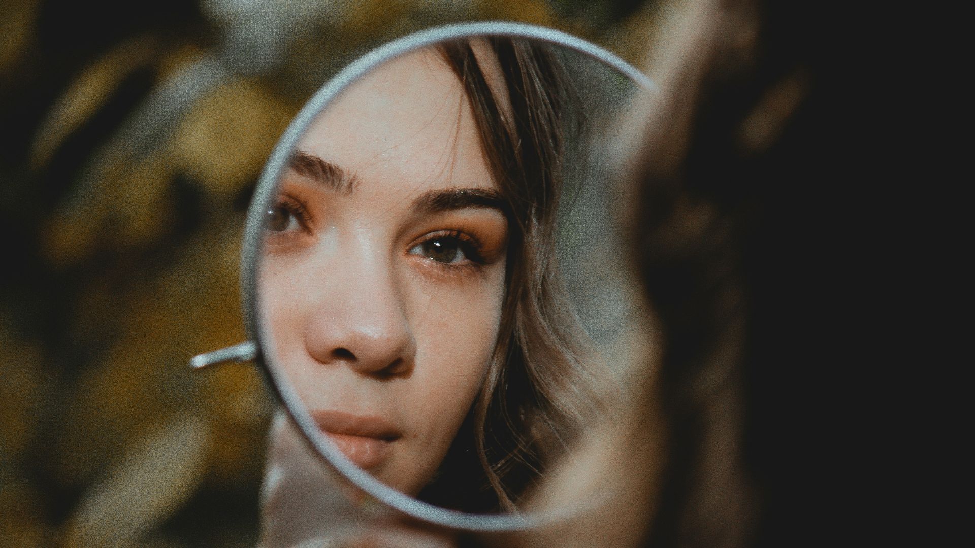 woman holding magnifying glass with brown liquid