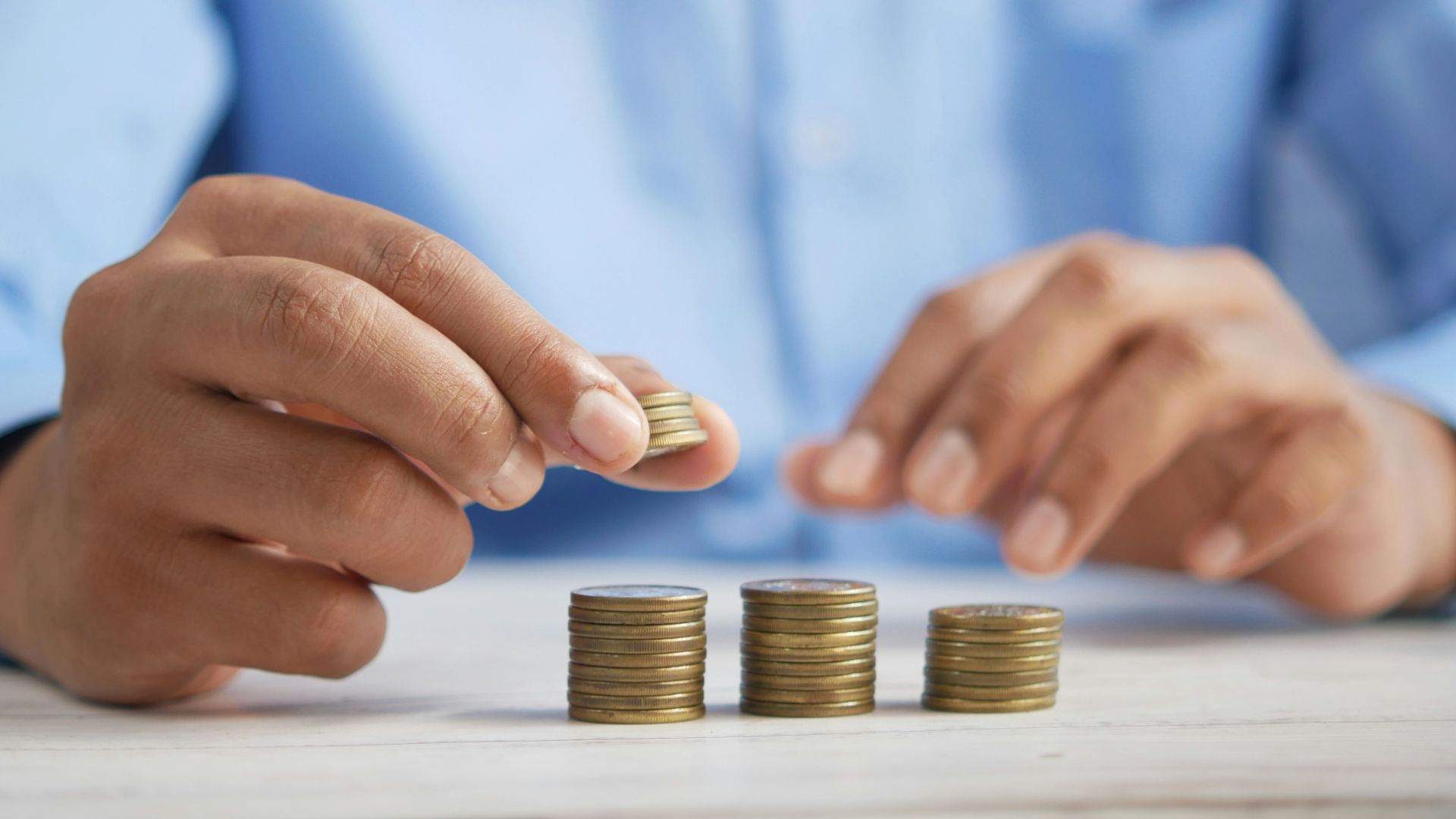 a person stacking coins on top of a table