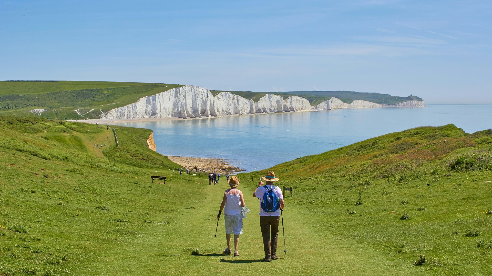 2 men standing on green grass field near body of water during daytime