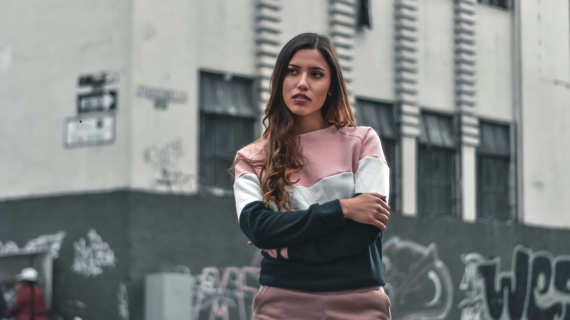 woman standing beside black and gray concrete building