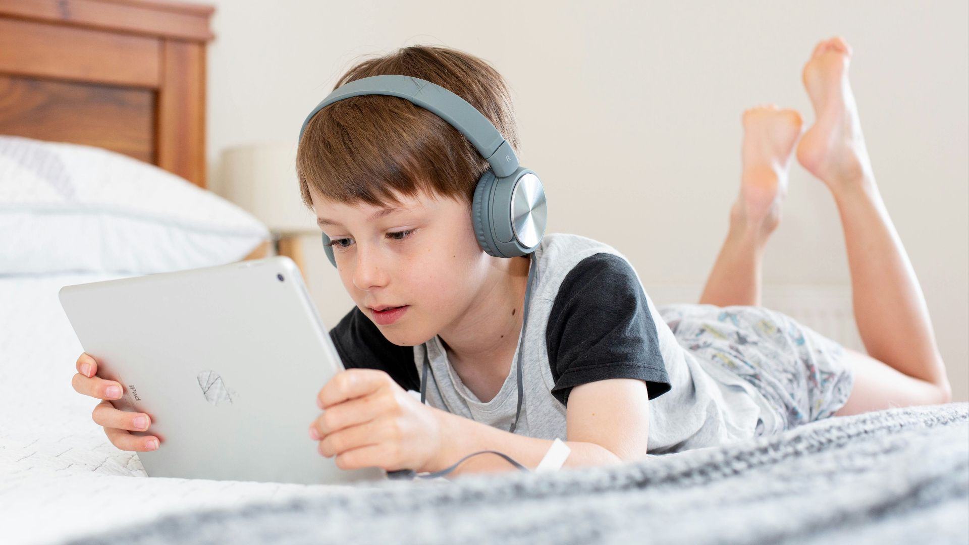 boy in black shirt using white laptop computer
