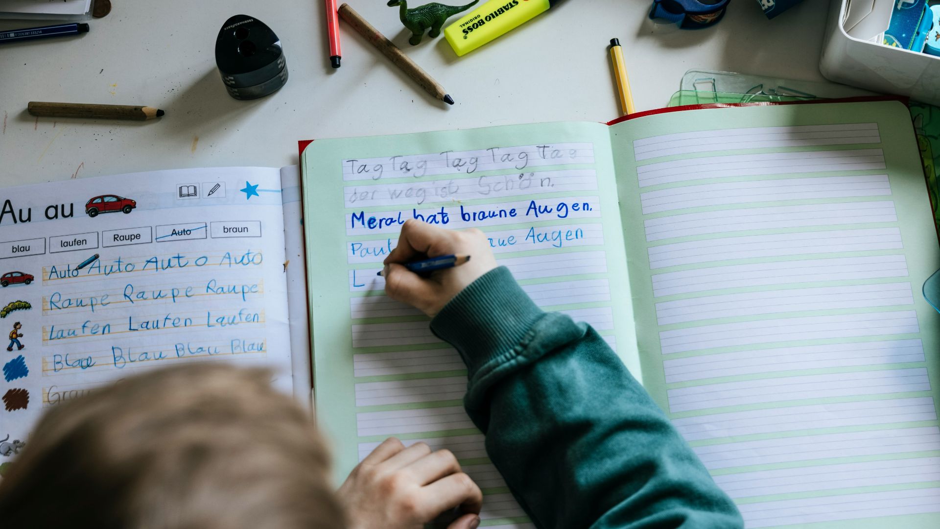 a person writing on a notebook with a pen
