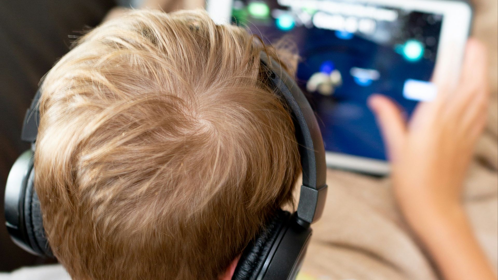 boy in white shirt using white tablet computer