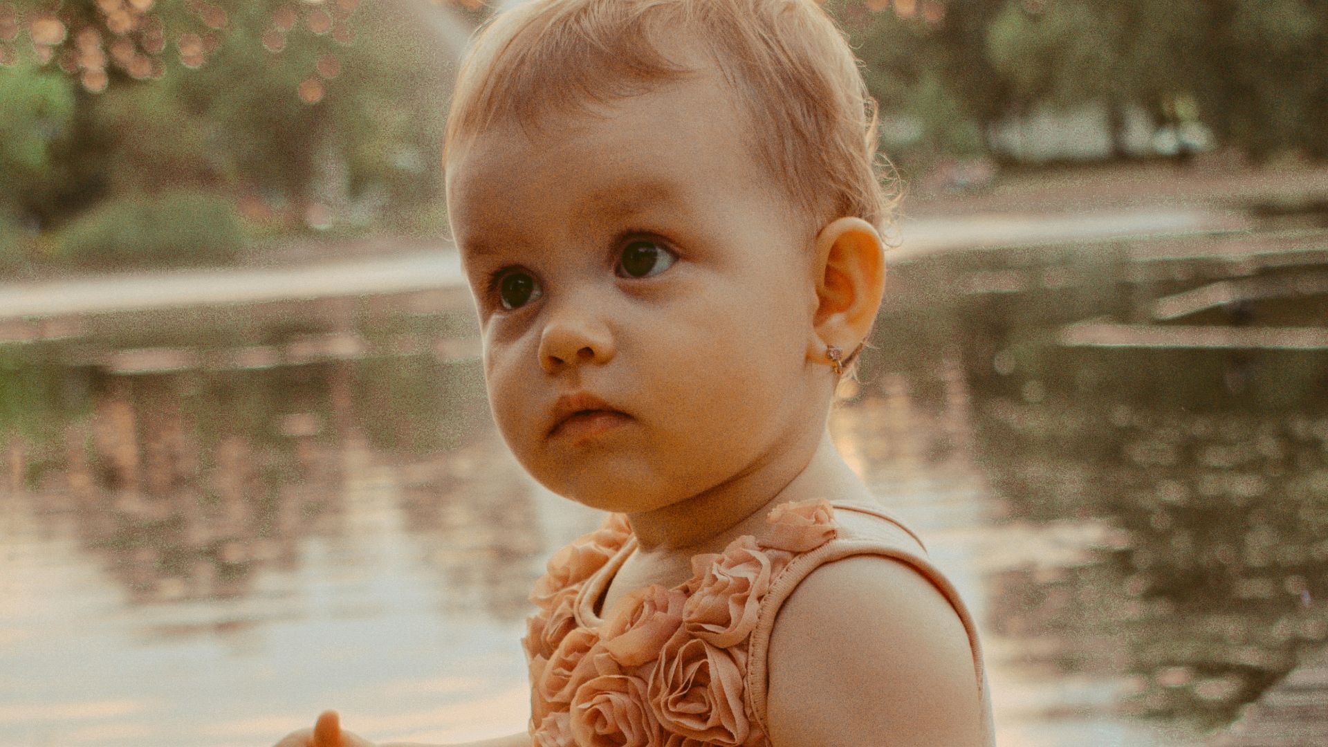 a baby girl sitting on a dock