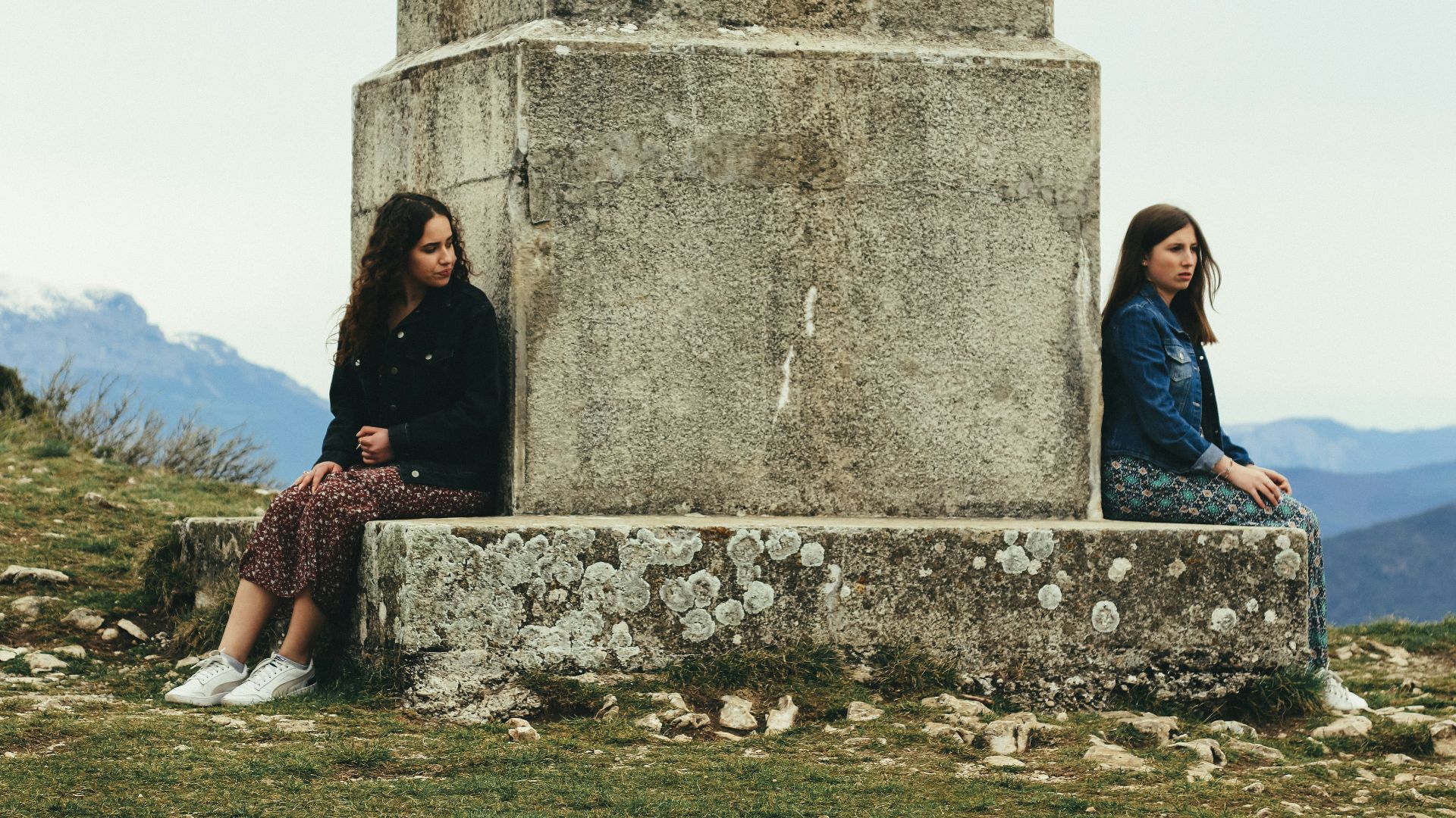 woman in black jacket sitting beside woman in black jacket