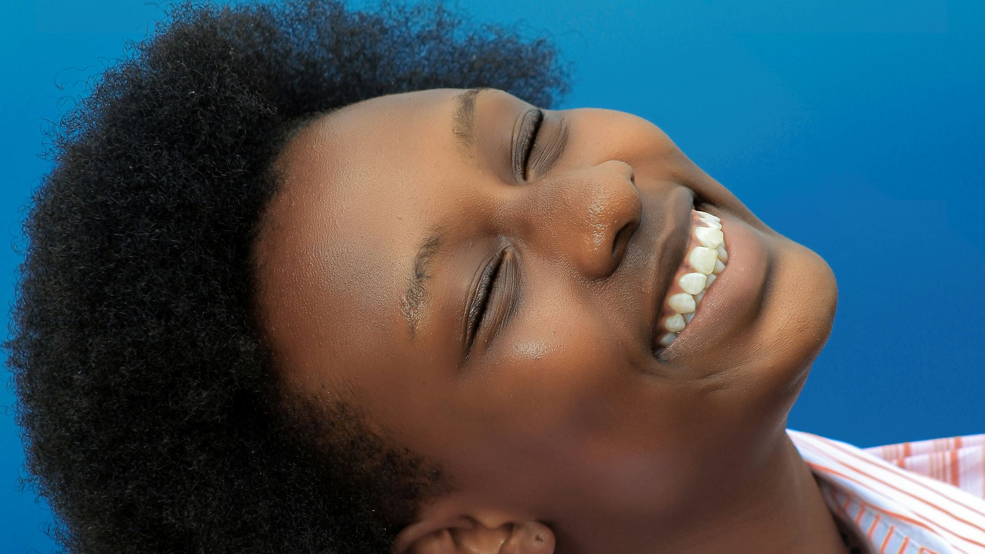 smiling girl in pink and white stripe shirt
